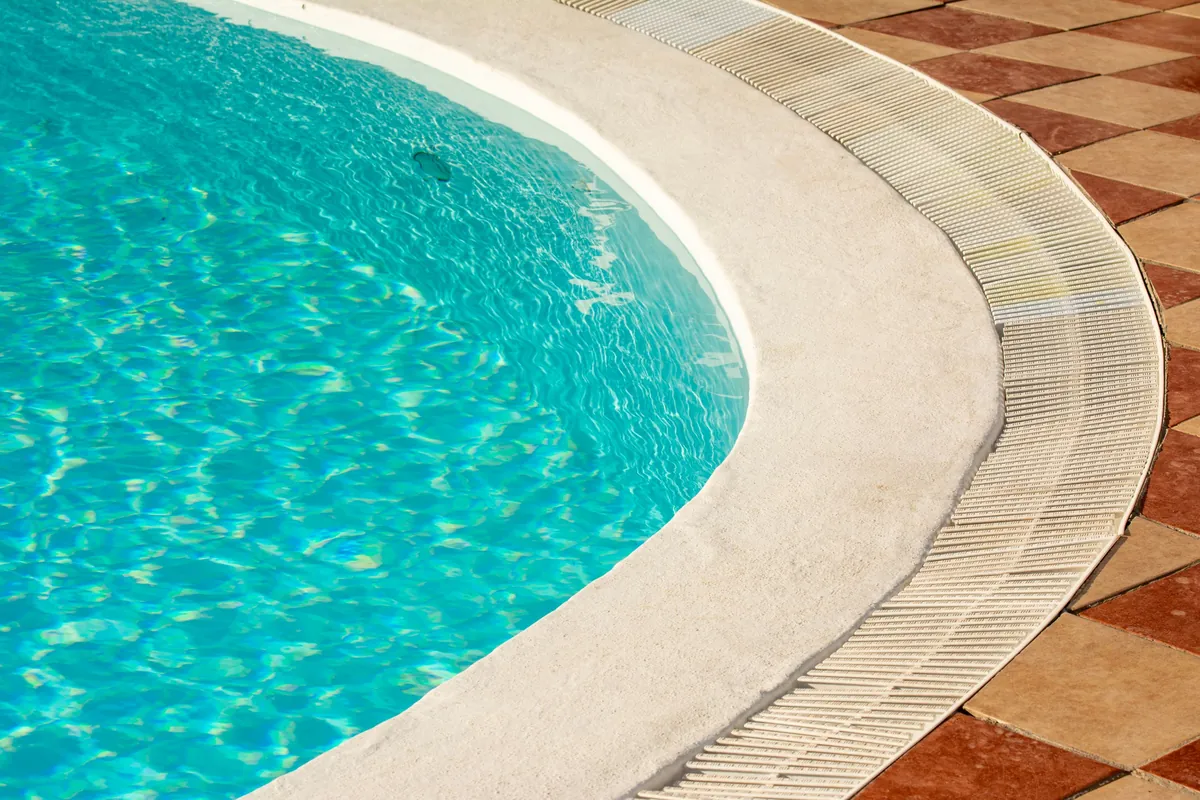Curved bullnose coping and deck tile around the edge of a pool